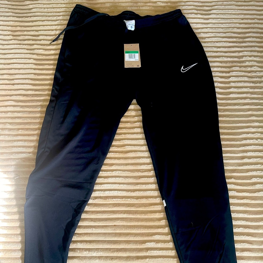 New with tags, Nike warm-up pants, black with a white horizontal stripe in back